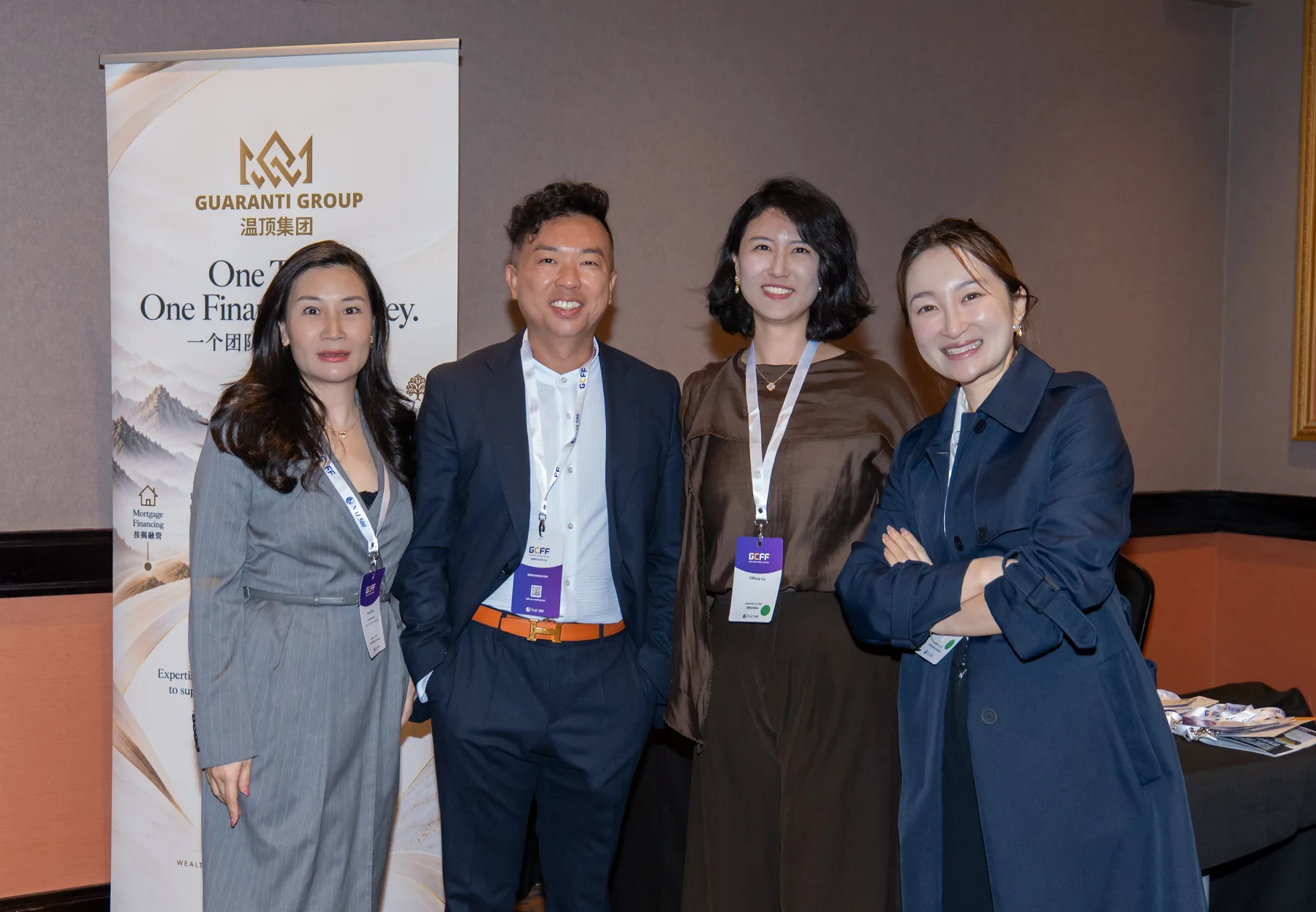 Guaranti team members and guests together beside the branded display