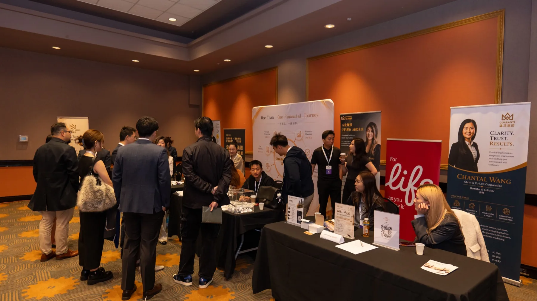 Conference visitors speaking with the Guaranti team at the booths