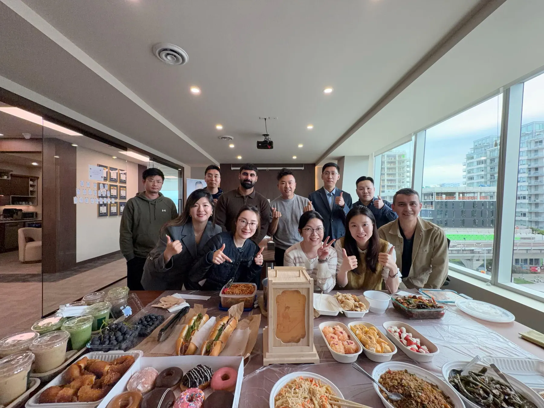 Guaranti team in a second group photo behind the food table